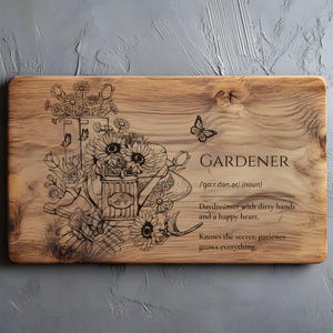 Op de afbeelding: Houten snijplank met een thema van de tuinman. De plank heeft een gegraveerde illustratie van tuingereedschap, bloemen en vlinders. De tekst bevat de definitie van "Tuinman" en een citaat over geduld.