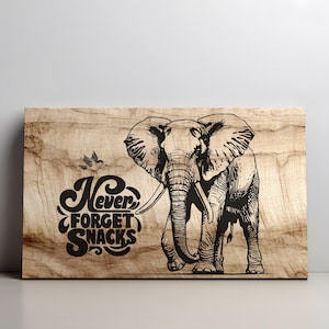 Peut inclure: Panneau en bois avec une illustration noire d'un éléphant et le texte "Never Forget Snacks". Le panneau présente un grain de bois naturel. L'illustration de l'éléphant est détaillée, avec des défenses. Un petit oiseau est également inclus.