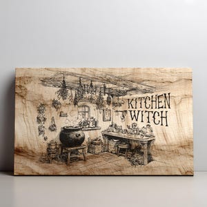 Könnte beinhalten: Holzschild mit einer detaillierten Schwarz-Weiß-Illustration einer Hexenküche. Das Schild zeigt einen Kessel, Kräuter und den Text "KITCHEN WITCH". Das Kunstwerk ist vor einem hellen Holzmaserungshintergrund platziert.