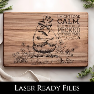 May include: A rectangular wooden cutting board with a laser-etched design. The design features an angry cartoon chicken with crossed arms, surrounded by grass and flowers. Text reads "I MIGHT LOOK CALM, BUT IN MY HEAD, I'VE PECKED YOU THREE TIMES."