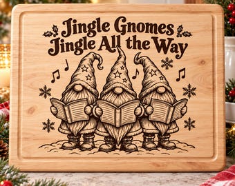 May include: A rectangular light-colored wooden cutting board featuring a dark brown laser-engraved illustration of three gnomes singing from books. The text reads Jingle Gnomes Jingle All the Way, accompanied by musical notes and snowflake icons.