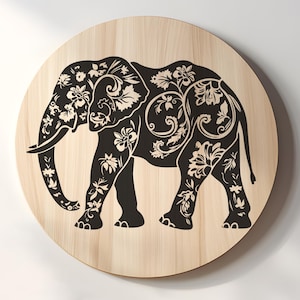 May include: A black silhouette of an elephant with intricate floral designs carved into its body. The elephant is standing on a light brown wooden background.