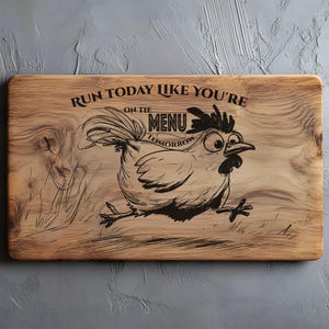 May include: Wooden cutting board with a cartoon chicken illustration and the text "Run today like you're on the menu tomorrow." The board is rectangular with rounded corners and a natural wood grain finish.
