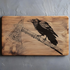 May include: A wooden cutting board with a detailed engraving of a raven perched on an axe. The axe features intricate patterns and designs. The raven is depicted in black, contrasting with the light brown wood.