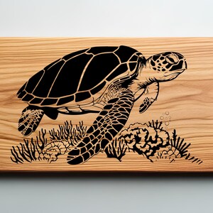 May include: A wooden cutting board with a black silhouette of a sea turtle swimming over coral. The turtle has a detailed shell and flippers.