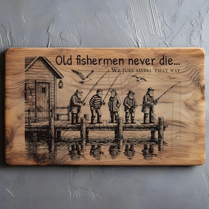 May include: Wooden chopping board featuring an engraved illustration of five fishermen on a pier, fishing. A small wooden hut is on the left. The text reads, "Old fishermen never die... We just smell that way."