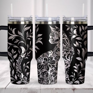 May include: Three black stainless steel tumblers with a silver floral design and a cat silhouette. The tumblers have a black handle and a clear lid.