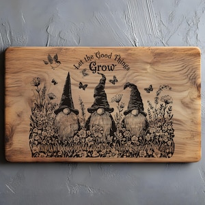 Peut inclure: Planche à découper en bois avec un motif décoratif. La planche présente trois gnomes dans un jardin, avec le texte "Let the Good Things Grow". Des papillons et un oiseau sont également inclus dans le design. La planche a un grain de bois naturel.