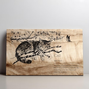 Peut inclure: Tableau en bois avec une illustration en noir et blanc d'un chat sur une branche fleurie et un papillon. Le mot "CAT" et une définition sont inclus. Le fond est en bois naturel.