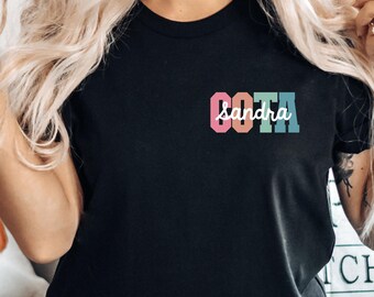 May include: A black t-shirt with a colorful graphic that says "GOTTA sandra".