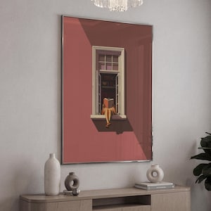 May include: A framed art print depicts a person reading a book while sitting in a window. The window is open, and the person is seated on the sill. The wall is painted a muted red, and the window frame is white. The art print is displayed above a wooden cabinet.