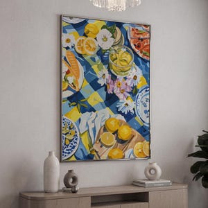 Peut inclure: Peinture encadrée représentant une scène de pique-nique. Une nappe à carreaux bleue et jaune est garnie de citrons, de fleurs et d'assiettes de nourriture. Un verre de limonade et des citrons tranchés sont également visibles. L'œuvre a une ambiance estivale.