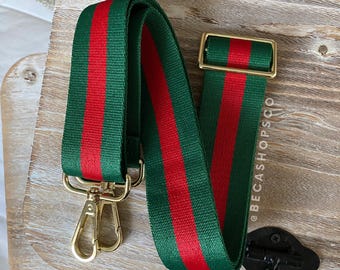 May include: Green and red striped bag strap with gold-colored metal hardware. The strap has a classic design with a central red stripe flanked by green stripes. The gold hardware includes a buckle and two swivel clasps.