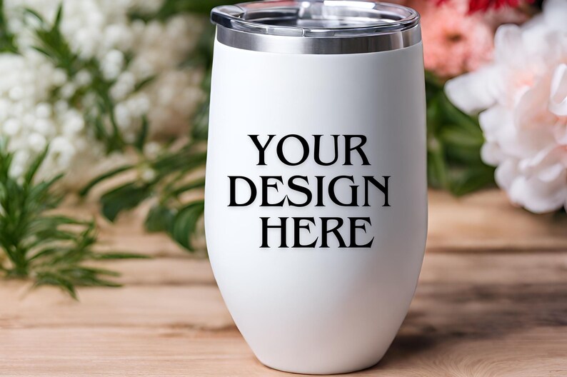 Peut inclure: Un gobelet &agrave; vin en acier inoxydable blanc avec un couvercle argent&eacute;. Le gobelet porte l'inscription "YOUR DESIGN HERE" imprim&eacute;e sur le devant.