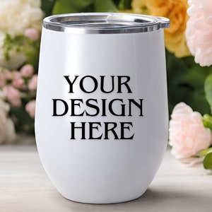 Peut inclure: Un gobelet &agrave; vin en acier inoxydable blanc avec un couvercle argent&eacute;. Le gobelet porte l'inscription "YOUR DESIGN HERE" imprim&eacute;e sur le devant.