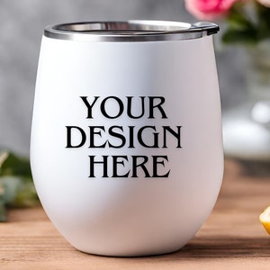 Peut inclure: Un gobelet &agrave; vin en acier inoxydable blanc avec un couvercle argent&eacute;. Le gobelet porte l'inscription "YOUR DESIGN HERE" imprim&eacute;e sur le devant.