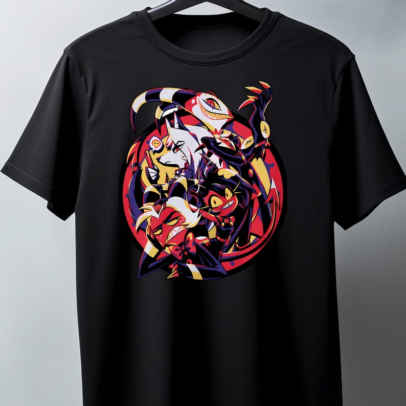 May include: Black t-shirt featuring a colorful graphic of several cartoon characters. The design includes characters with red, white, yellow, and black details, set against a red and purple circular background. The shirt has a crew neck and short sleeves.