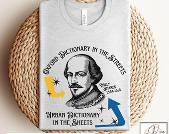 May include: A light gray t-shirt featuring a portrait of William Shakespeare with the text "Oxford Dictionary in the Streets" and "Urban Dictionary in the Sheets." The shirt includes yellow and blue arrow graphics and the text "Available in 7 Shirt Colors."