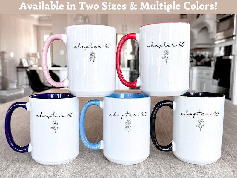 May include: Five white ceramic mugs with the text "chapter 40" and a small floral line drawing. Each mug features a different colored handle and interior rim: light pink, red, dark blue, light blue, and black. The mugs are arranged in a group.