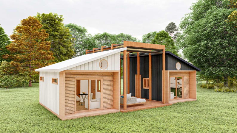 May include: A modern cabin featuring a split design with a white section and a black section, connected by a wooden pergola structure. The exterior includes sliding glass doors, circular windows, and horizontal wood siding accents on a grassy lawn.