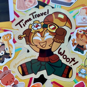 May include: A sticker featuring a cartoon character in a time travel theme. The character is wearing goggles and a brown and green outfit, with the words "Time Travel" and "Woot!" on the sticker. Other food-themed stickers are also visible.