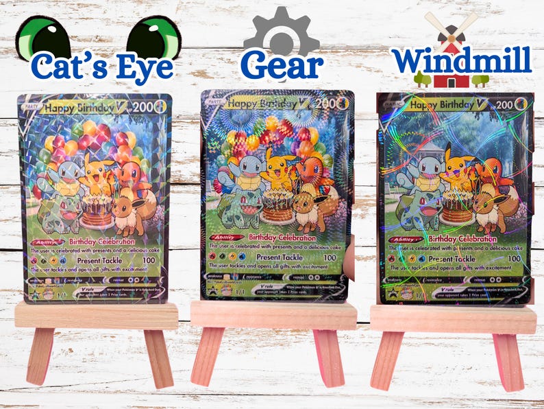 May include: Three Happy Birthday V trading cards displayed on small wooden easels. Each card features Pikachu, Squirtle, Charmander, Bulbasaur, and Eevee with a birthday cake and balloons. The cards have distinct holographic patterns: Cat's Eye, Gear, and Windmill.