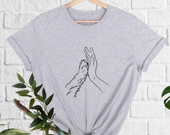 thumbnail image 2 of Human Hand Cradling Dog Paw With Care 2 of 11