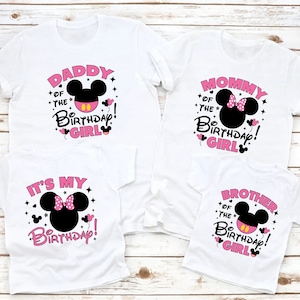 Puede incluir: Cuatro camisetas blancas con siluetas negras de Mickey Mouse y texto rosa. Las camisetas dicen "Daddy of the Birthday Girl", "Mommy of the Birthday Girl", "It's My Birthday!" y "Brother of the Birthday Girl!" Las camisetas son para una familia.