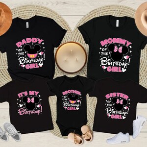 Puede incluir: Camisetas negras con texto rosa y blanco y un dise&ntilde;o de cabeza de Mickey Mouse. Las camisetas dicen "Daddy of the Birthday Girl", "Mommy of the Birthday Girl", "It's My Birthday", "Brother of the Birthday Girl" y "Sister of the Birthday Girl".
