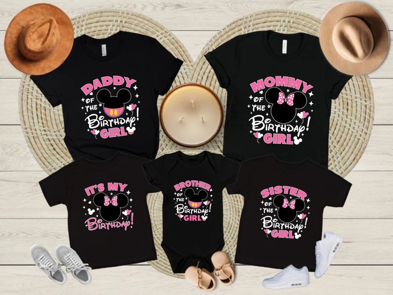 Puede incluir: Camisetas negras con texto rosa y blanco y un dise&ntilde;o de cabeza de Mickey Mouse. Las camisetas dicen "Daddy of the Birthday Girl", "Mommy of the Birthday Girl", "It's My Birthday", "Brother of the Birthday Girl" y "Sister of the Birthday Girl".