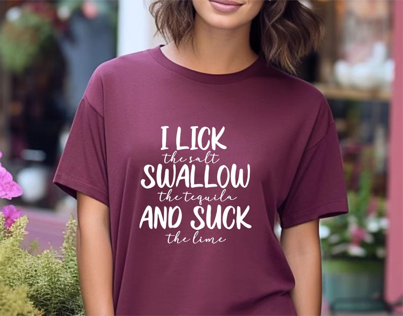 May include: A maroon t-shirt with white text that reads "I lick the salt swallow the tequila and suck the lime".