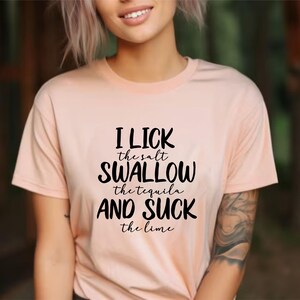 May include: A peach-colored t-shirt with black text that reads "I lick the salt swallow the tequila and suck the lime".