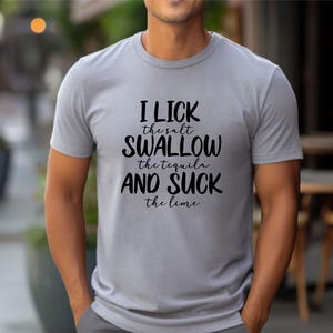 May include: A gray t-shirt with the text "I lick the salt, swallow the tequila and suck the lime" printed in black.