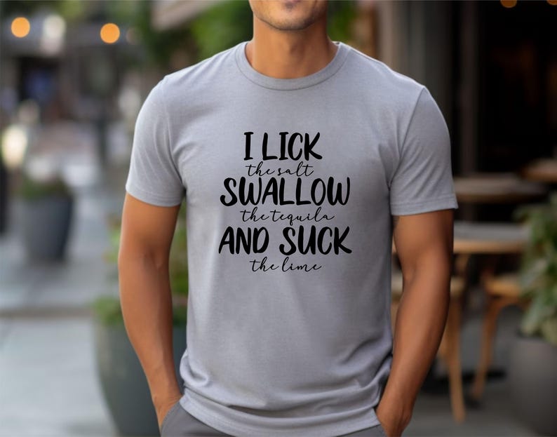 May include: A gray t-shirt with the text "I lick the salt, swallow the tequila and suck the lime" printed in black.