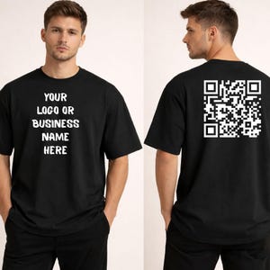 May include: Black t-shirt with white text on the front that reads "YOUR LOGO OR BUSINESS NAME HERE." The back of the shirt features a white QR code. The shirt is a basic crew neck style.