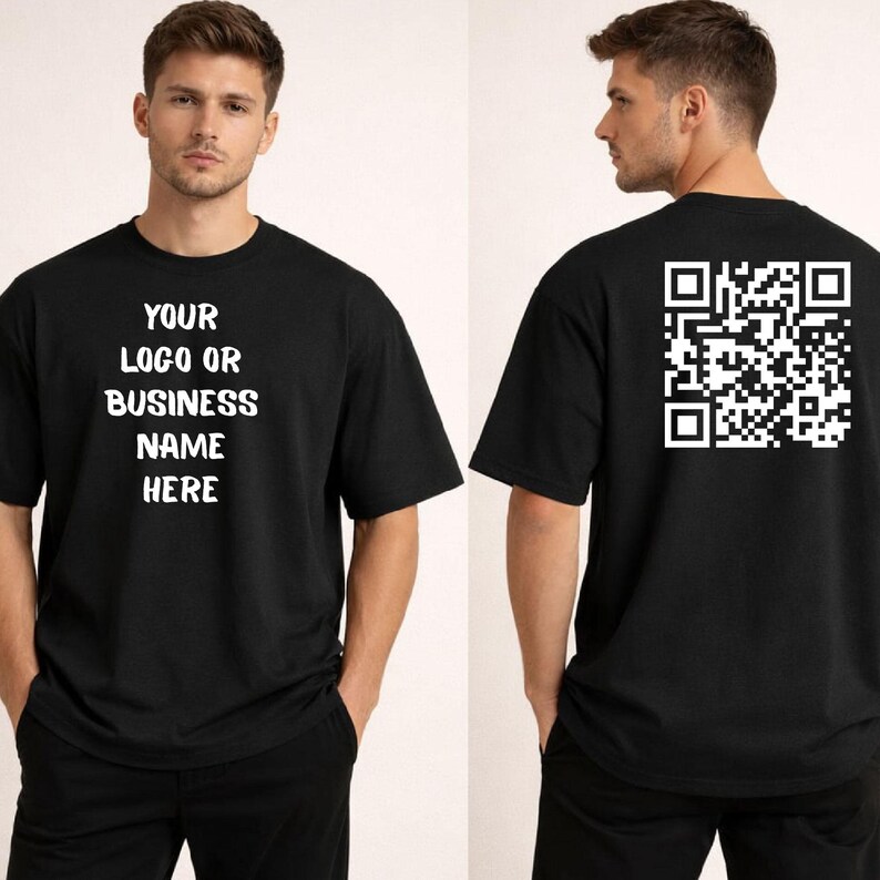May include: Black t-shirt with white text on the front that reads "YOUR LOGO OR BUSINESS NAME HERE." The back of the shirt features a white QR code. The shirt is a basic crew neck style.