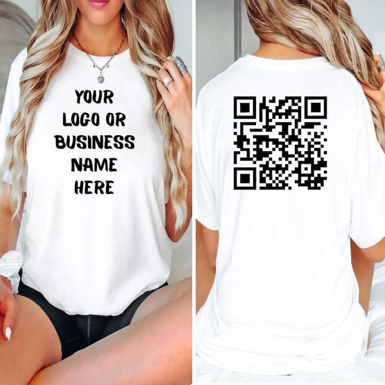 May include: White t-shirt with the text "YOUR LOGO OR BUSINESS NAME HERE" on the front. The back of the shirt features a black QR code. The shirt is a casual, unisex style.