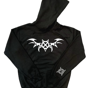 May include: Black hooded sweatshirt with a white tribal design on the front and sleeve. The design features a central emblem with wing-like elements extending outwards. The hoodie has a drawstring and a kangaroo pocket.