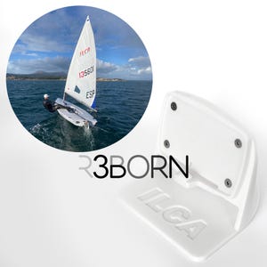 Op de afbeelding: Witte ILCA-zeilbootwandbevestiging met de tekst "ILCA" en "R3BORN" erop gedrukt. De bevestiging heeft zes schroefgaten en is ontworpen om een zeilboot te houden.