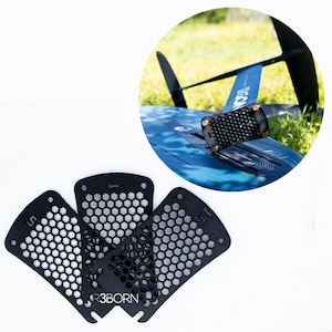 Puede incluir: Cuatro almohadillas de tracción de panal de abeja negras con el texto "R3BORN" impreso en una de las almohadillas. Las almohadillas están diseñadas para ser utilizadas en una tabla de surf u otro equipo de deportes acuáticos.