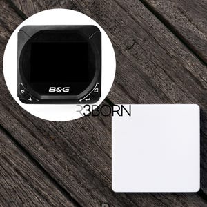 Puede incluir: Una pantalla B&G en blanco y negro con una pantalla y botones. La pantalla está sobre una superficie de madera junto a un cuadrado blanco.