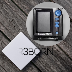 Può includere: Un ecoscandaglio NAVMAN nero con schermo e pulsanti di controllo blu. Il testo "FISH 4431" è sopra lo schermo. Un quadrato bianco con il testo "R3BORN" è nell'angolo in basso a sinistra.