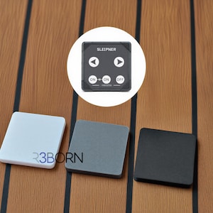 May include: A black Sleipner control panel with directional arrows and "ON" and "OFF" buttons is displayed. Three square pads in white, grey, and black are arranged below the panel. The white pad has the text "R3BORN".