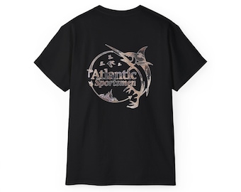 May include: Black t-shirt featuring a circular design with the text "Atlantic Sportsmen." The design includes a marlin, birds, and a camouflage pattern. The shirt is made of a soft material and has short sleeves.