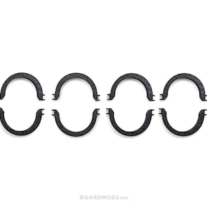 May include: Set of six black plastic rings, each with a rounded shape and a slight curve. The rings are arranged in two rows of three, with the top row slightly offset from the bottom row.