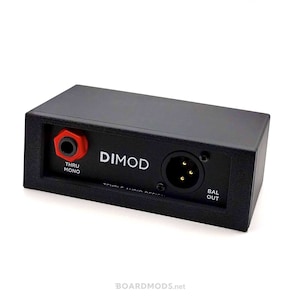 May include: Black rectangular audio device with the text "DIMOD" and "TEMPLE AUDIO DESIGN". Features a red and black input jack labeled "THRU MONO" and a balanced output port labeled "BAL OUT".