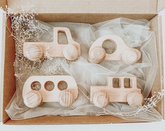 May include: A set of four wooden toy cars in a box. The cars are all different shapes and sizes, and they are made of natural wood. The cars are a great way for children to learn about different types of vehicles.