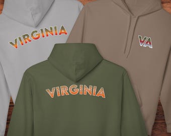 Könnte beinhalten: Drei Kapuzenpullover in Grau, Olivgrün und Beige. Die grauen und olivgrünen Sweatshirts haben "VIRGINIA" in einem orange-gelben Design auf der Brust aufgedruckt. Das beige Sweatshirt hat "VA" in einem ähnlichen Design. In der unteren rechten Ecke steht der Text "@TROUTSTATELINES".