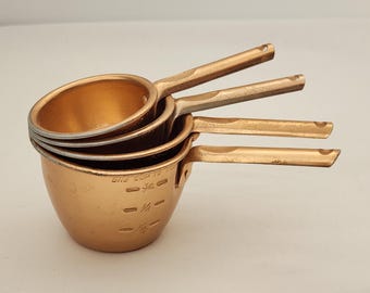 Juego de 4 tazas medidoras de aluminio Color Craft, estilo vintage de los años 50. Aluminio color cobre, con marcas de uso. Medidas: 1, 1/2, 1/3 y 1/4 de taza. Estilo rústico de granja.