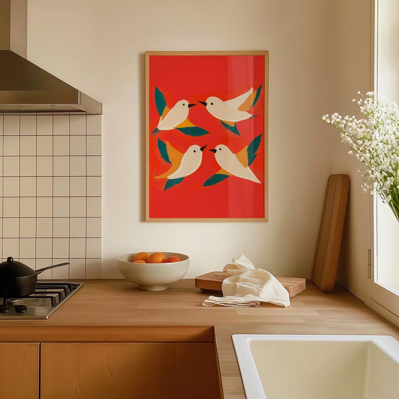 May include: A framed print of four white birds with yellow beaks flying against a red background. The birds are surrounded by green leaves.